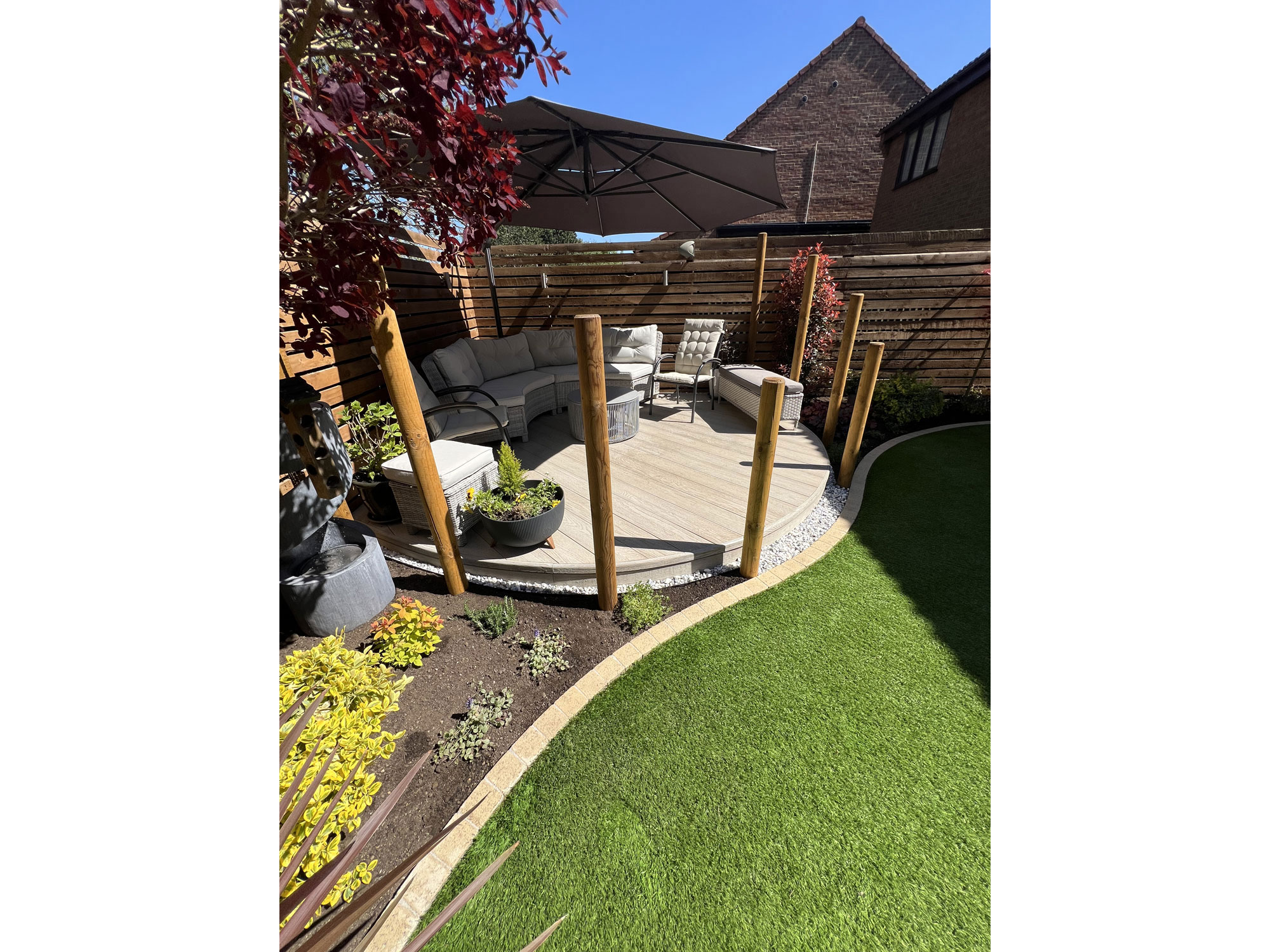 Curved garden layout combining porcelain paving, composite decking and bespoke oak features