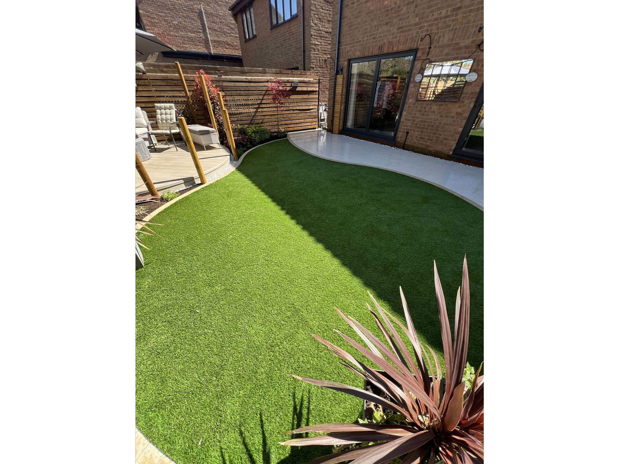 Luxury garden design with circular Millboard decking and curved porcelain patio tiles