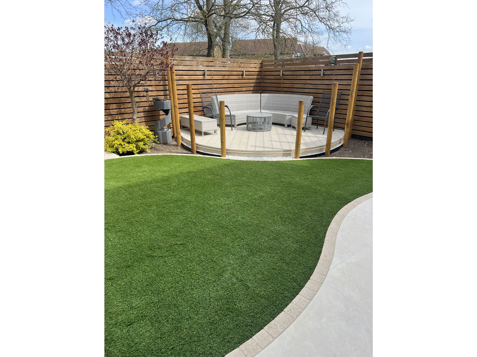 Contemporary garden design with curved porcelain paving and circular garden features