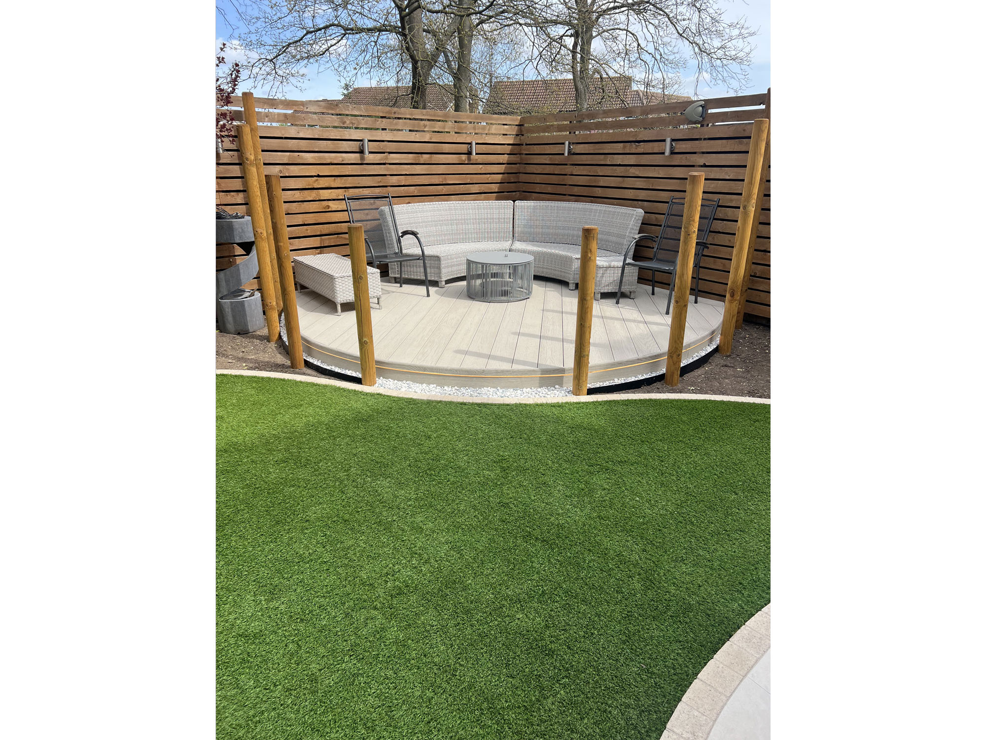 Curved porcelain patio creating flowing circular shapes within a landscaped garden