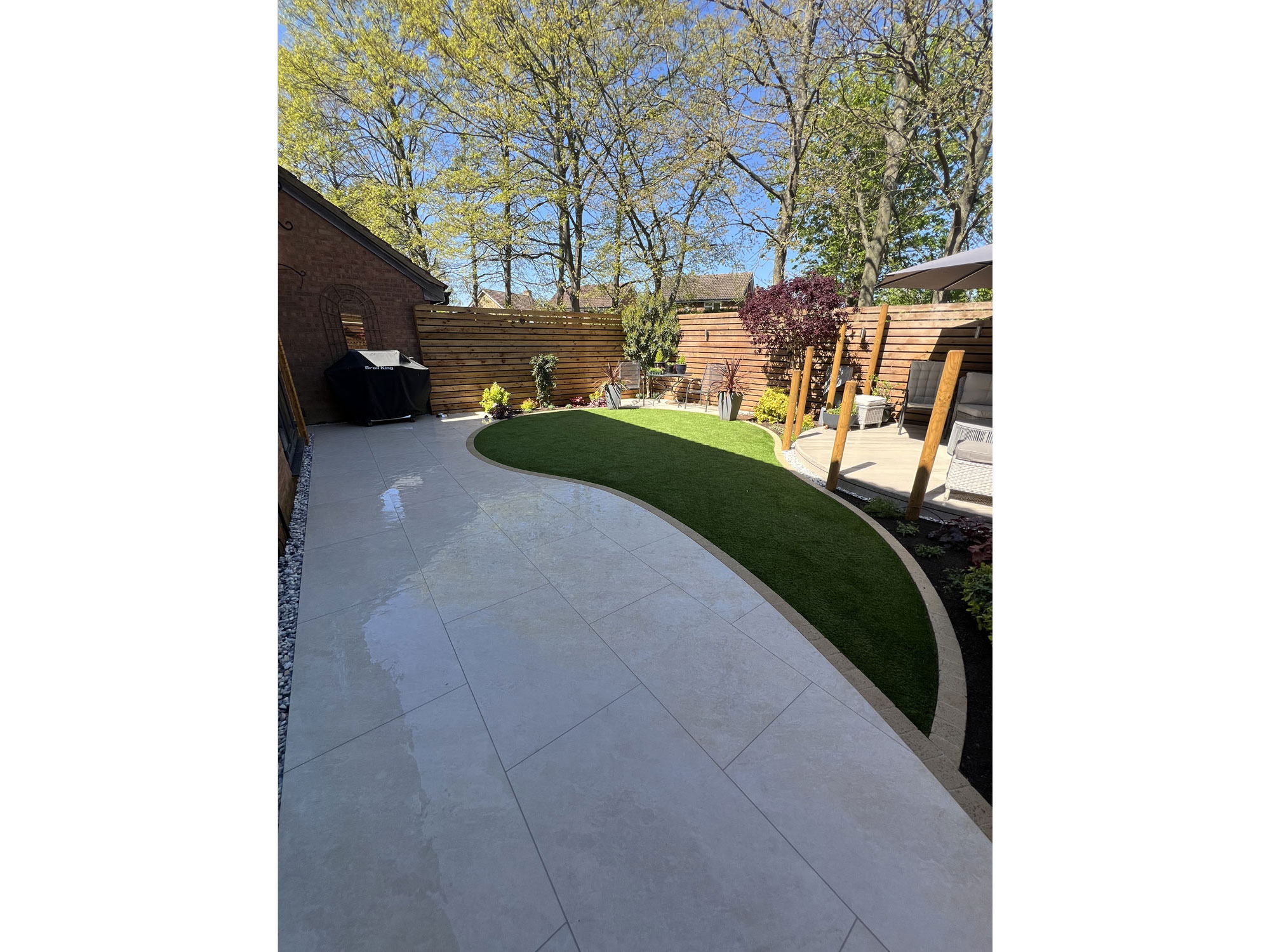 Bespoke garden landscaping with curved porcelain paving and natural oak features