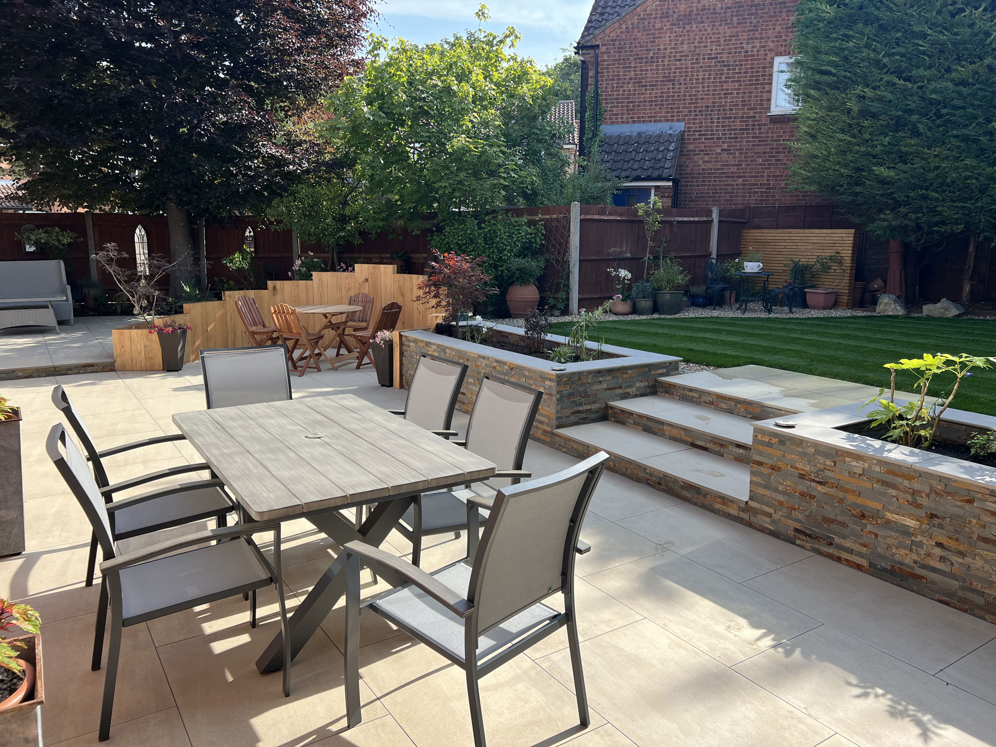Landscaped garden transformation with porcelain paving and oak garden features in Hertfordshire