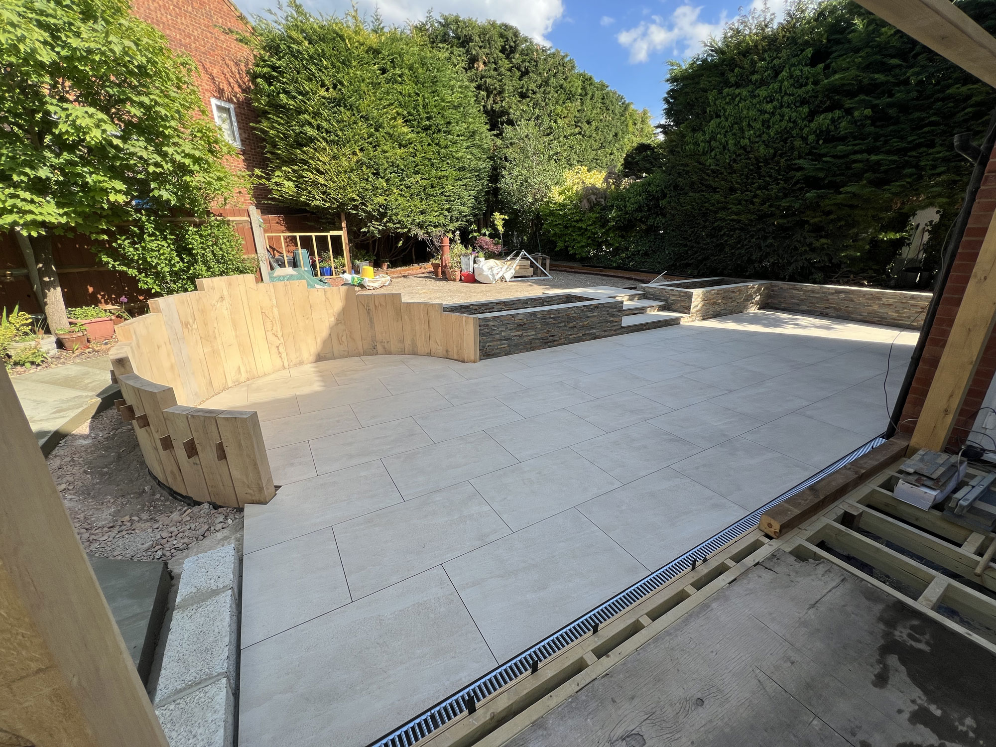 Luxury landscaped garden with porcelain patio tiles, Millboard decking and oak features