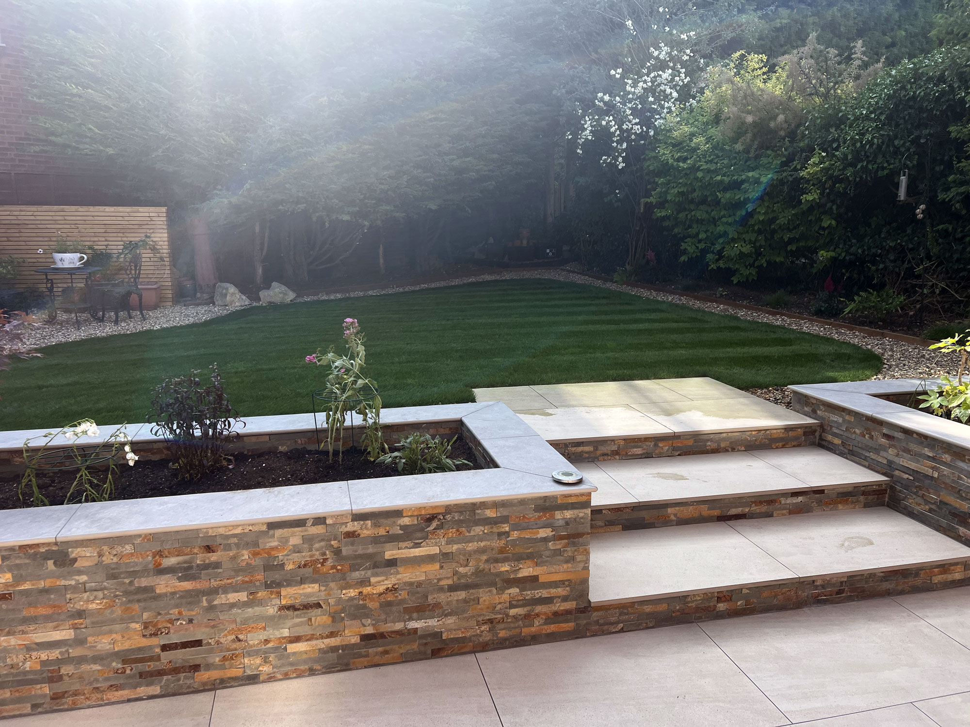 Beautiful garden landscaping with contemporary porcelain tiles and bespoke oak garden features