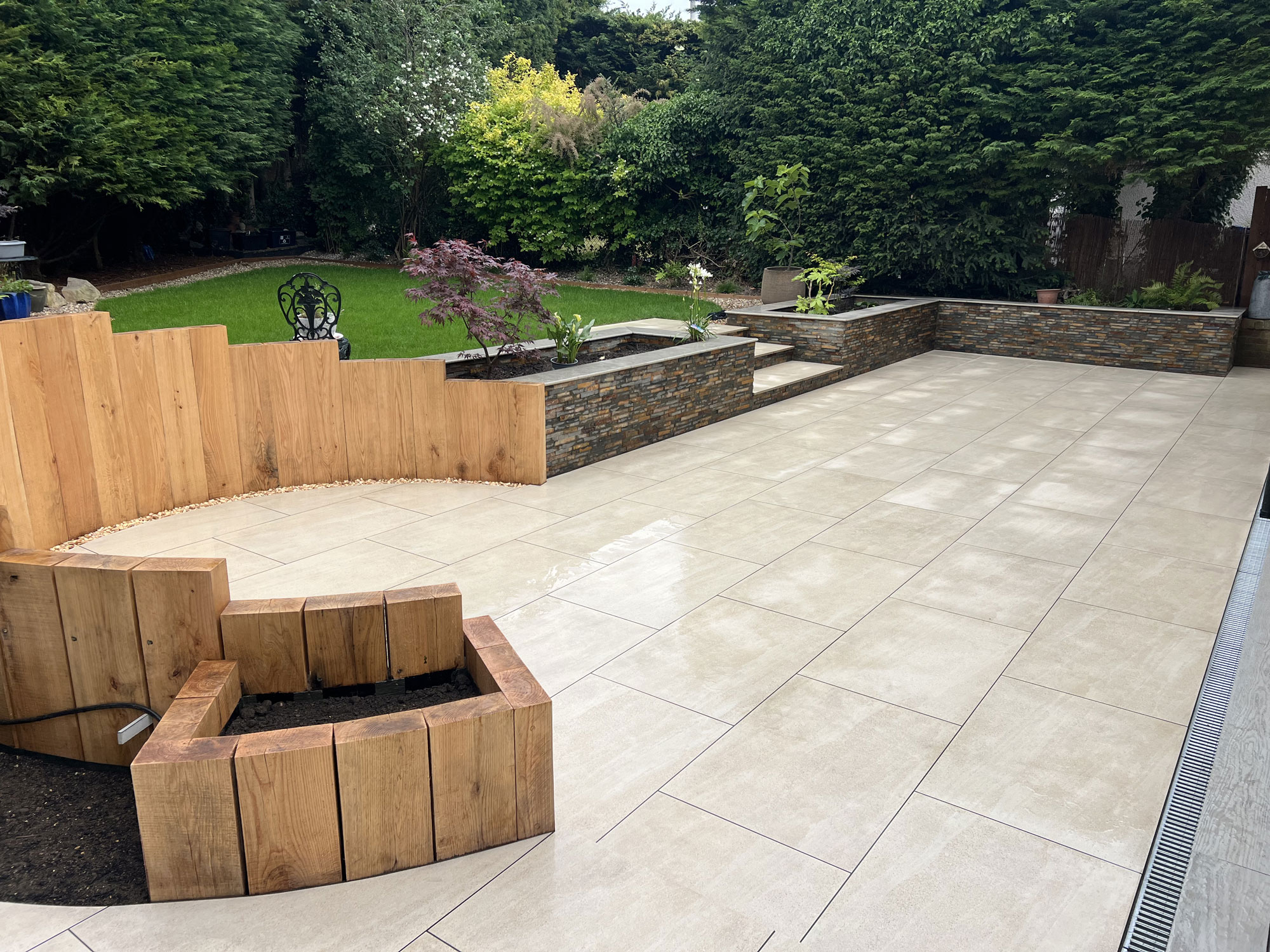Beautiful bespoke garden transformation with porcelain paving, decking and oak landscaping features