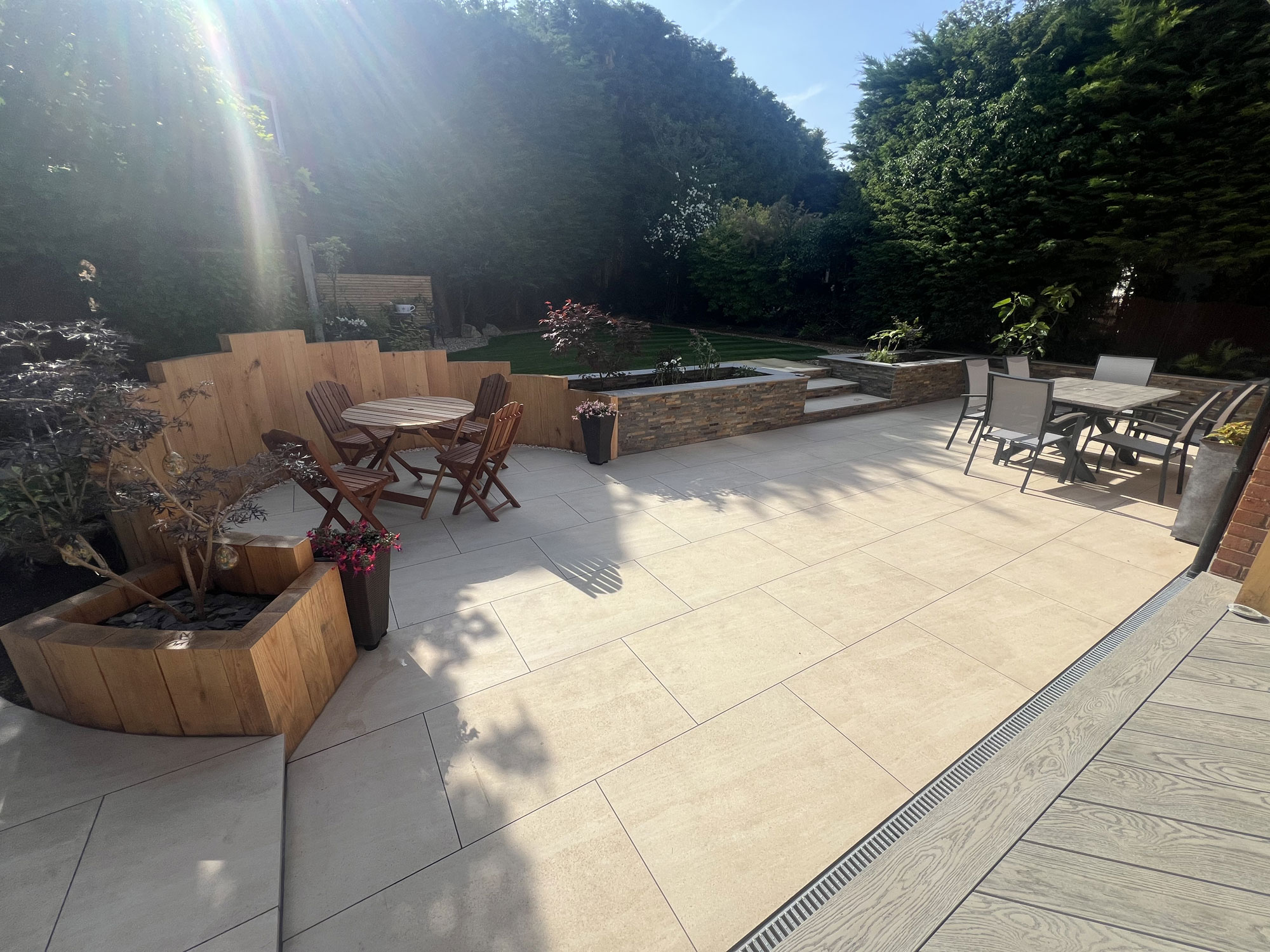 Luxury garden transformation featuring porcelain patio tiles and natural oak landscaping features