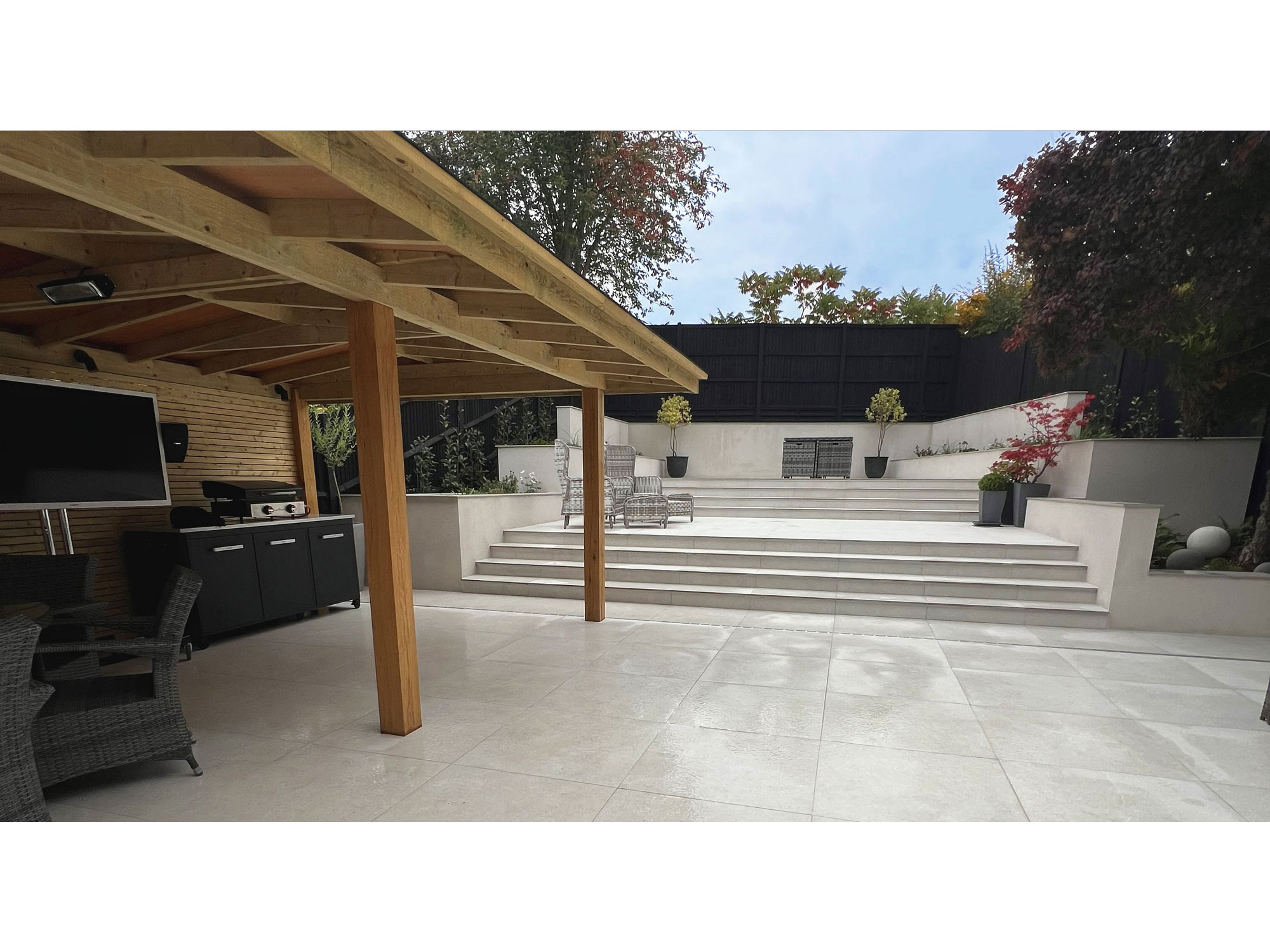 Modern porcelain patio with large-format porcelain paving and contemporary garden design