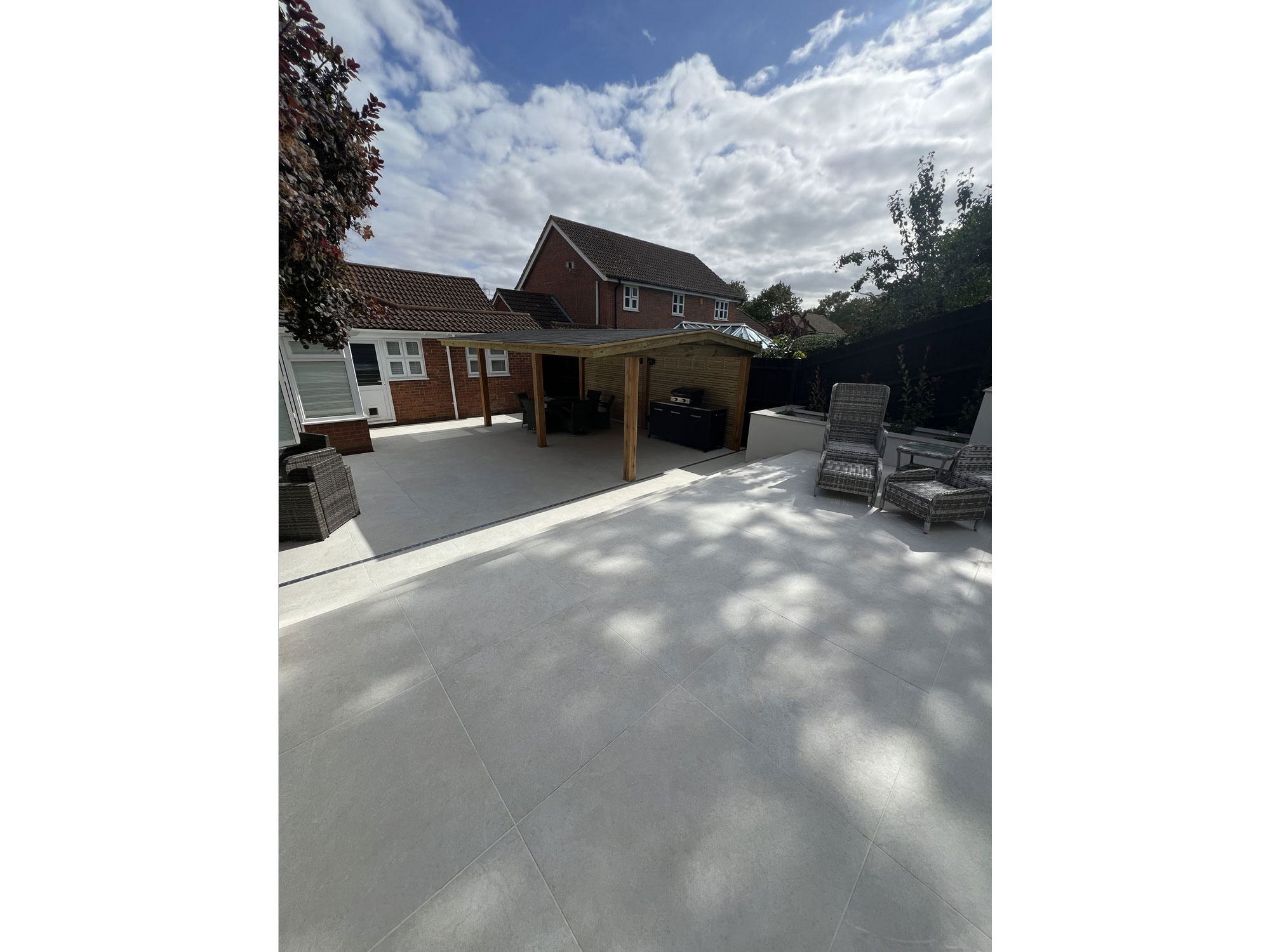 Contemporary porcelain patio with large-format tiles and integrated garden planting