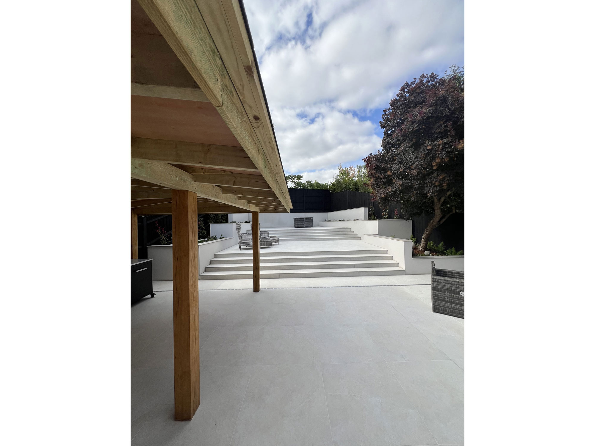 Wooden gazebo and porcelain patio creating an inviting outdoor living space