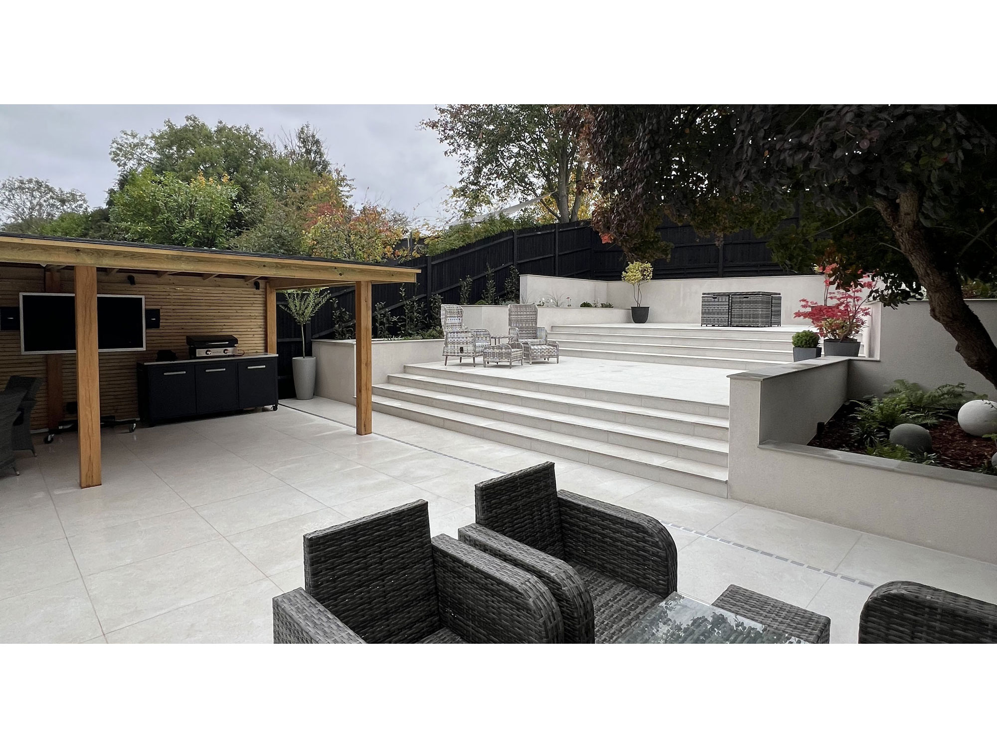 Contemporary porcelain patio with stylish outdoor seating and landscaped garden