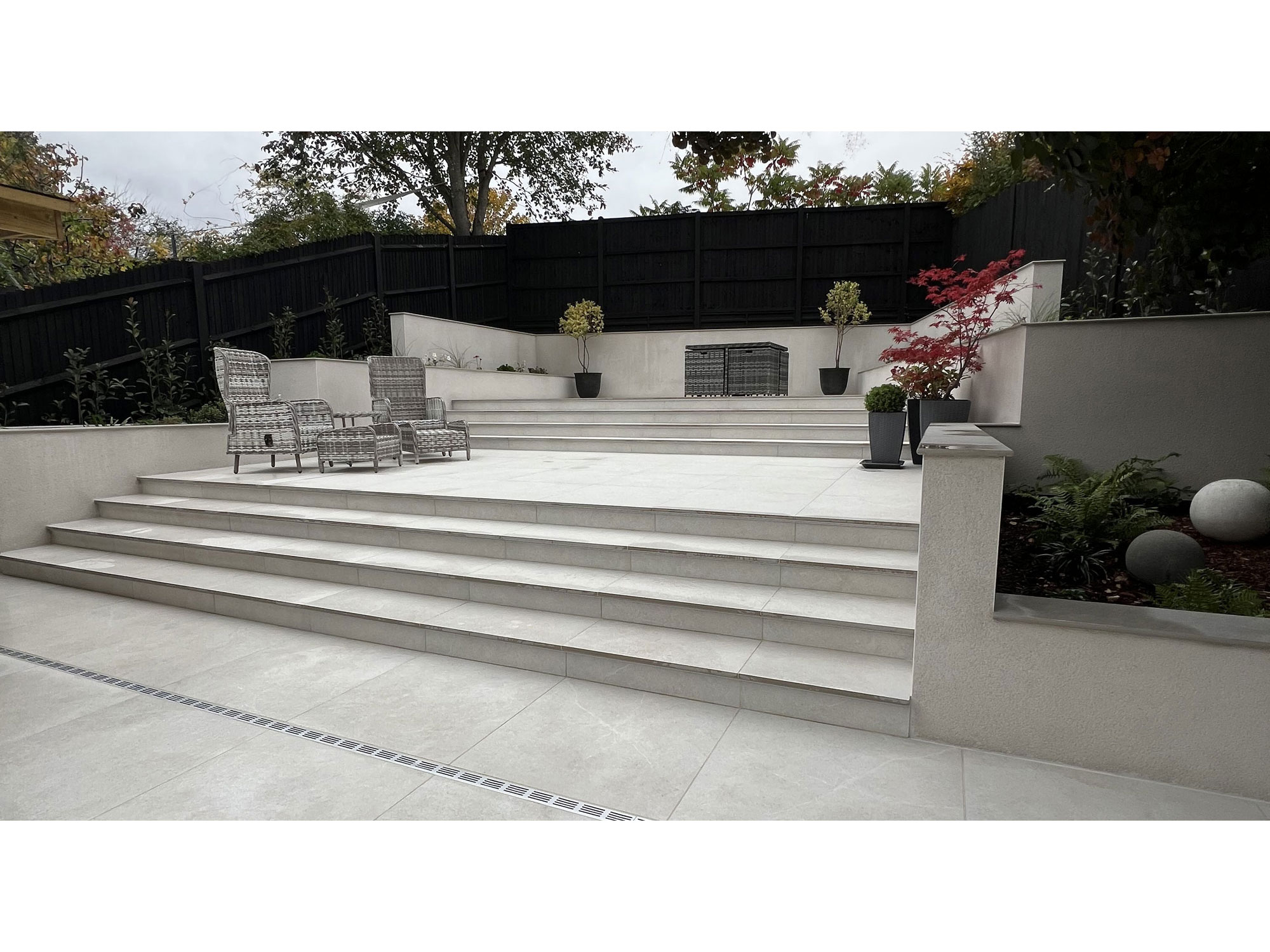 Large-format porcelain tiles creating a modern garden patio and outdoor living area