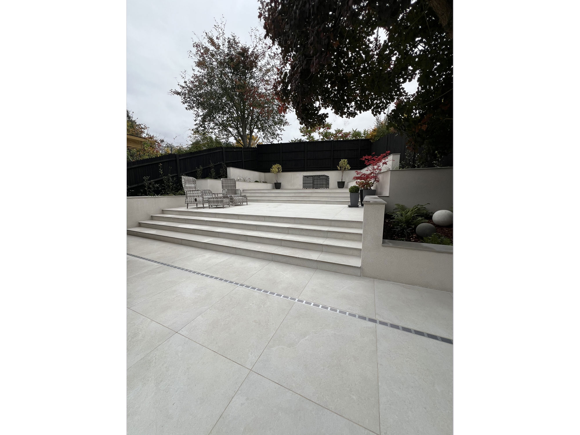 Beautiful tiered garden with porcelain paving and landscaped planting areas